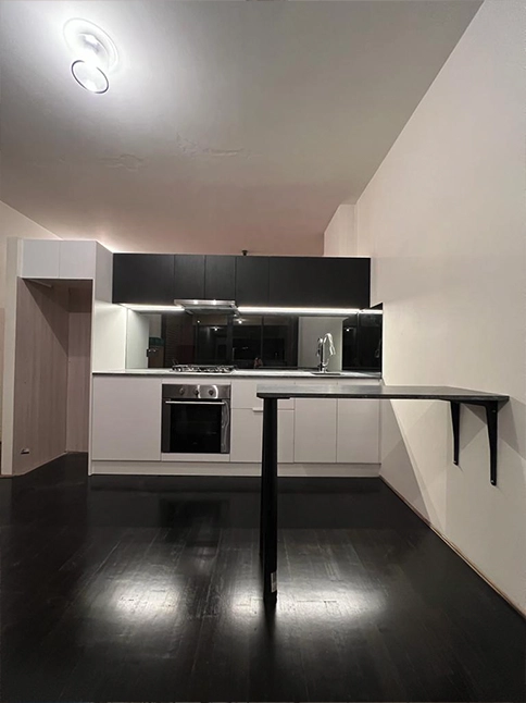 two toned kitchen, small kitchen renovation, black kitchen cabinetry, white kitchen cabinetry, mirror splash back, stone bench top