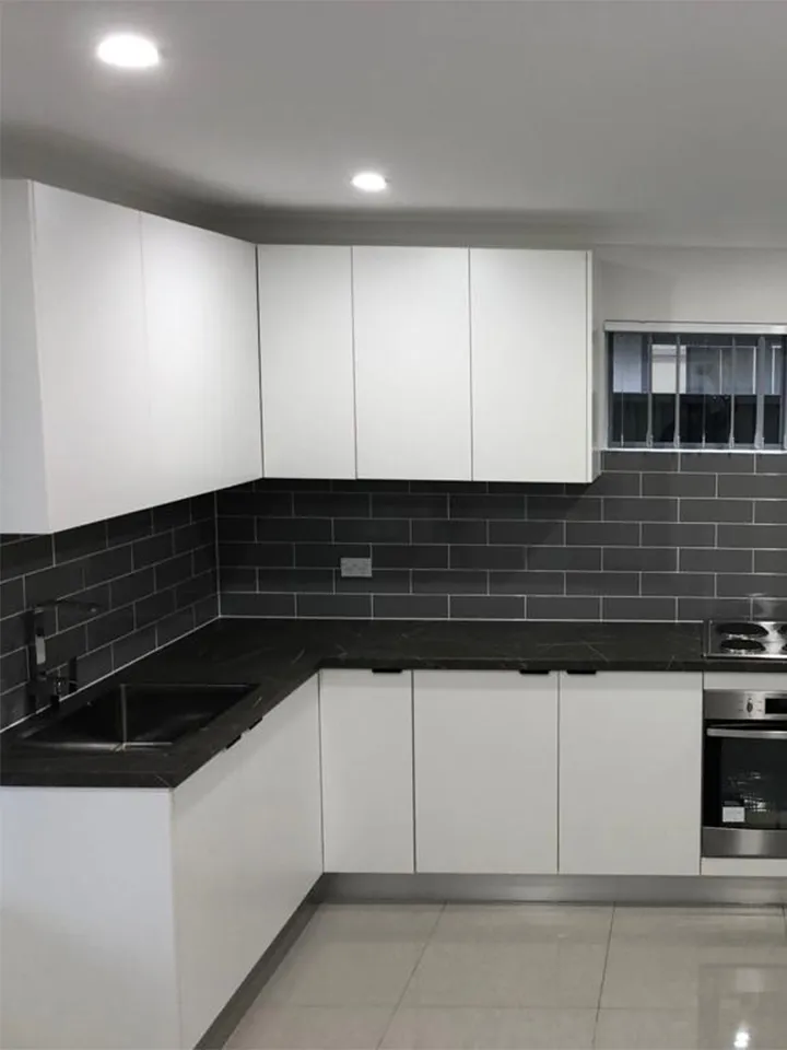 small kitchen, granny flat kitchen, white kitchen cabinetry, black handles, stone bench top