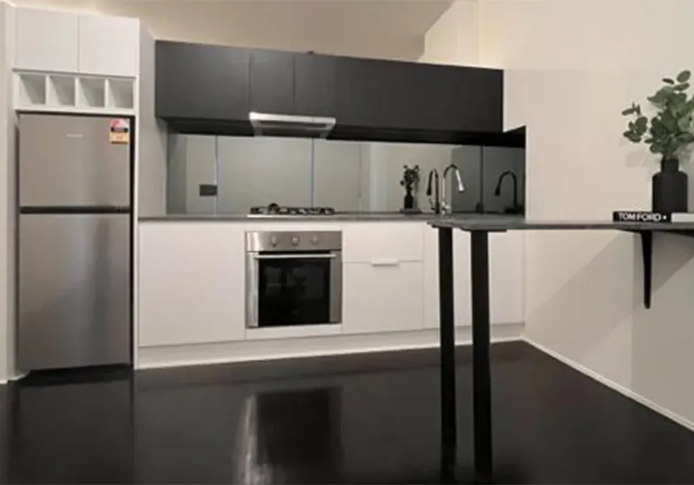 modern two tone studio apartment kitchen with 20mm stone bench top and mirror splash back